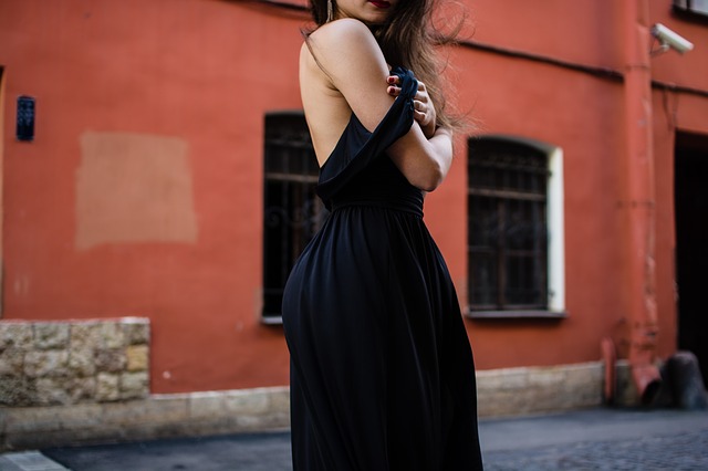 Dziewczyna w ciemnej sukni odsłaniającej ramię